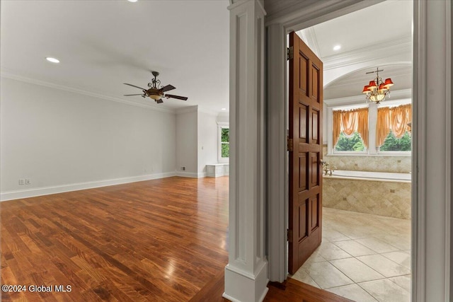 hallway with a chandelier, light hardwood / wood-style floors, and ornamental molding