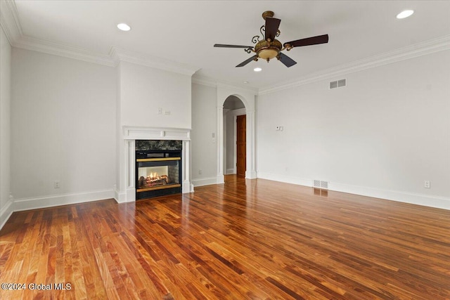 unfurnished living room featuring ornamental molding, ceiling fan, a fireplace, and hardwood / wood-style flooring