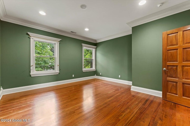 spare room featuring hardwood / wood-style flooring and ornamental molding