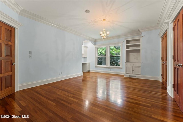 unfurnished living room with built in features, a chandelier, dark hardwood / wood-style floors, and ornamental molding