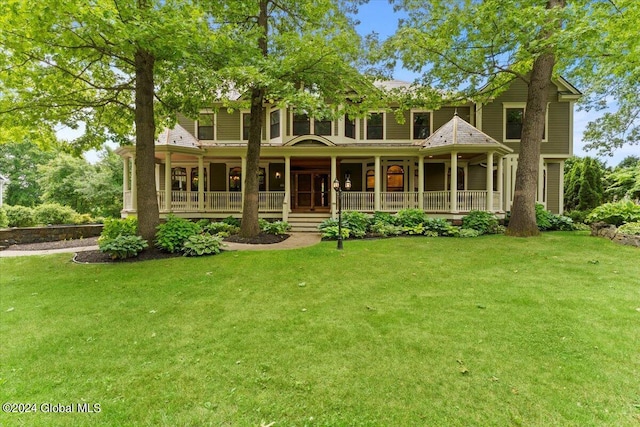 rear view of property featuring a yard and a porch