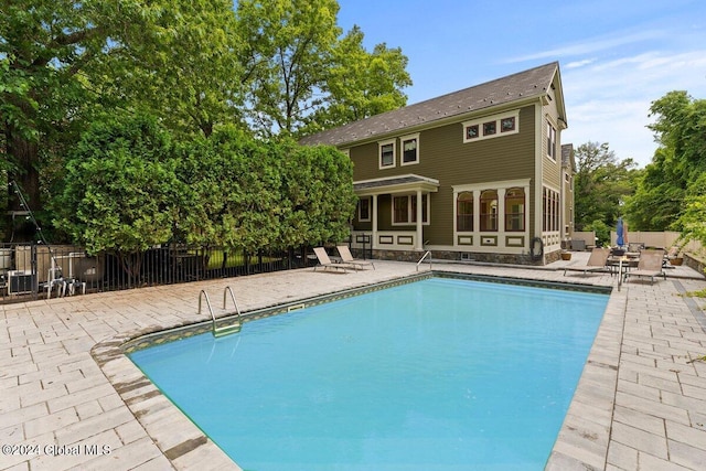 view of swimming pool with a patio and central air condition unit