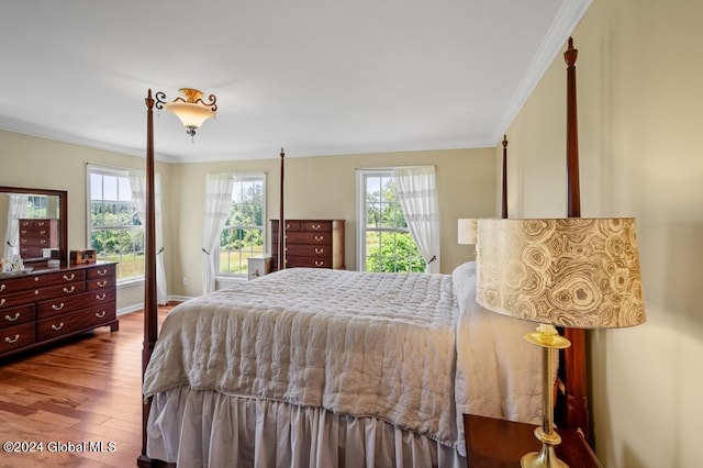 bedroom with hardwood / wood-style floors, crown molding, and multiple windows