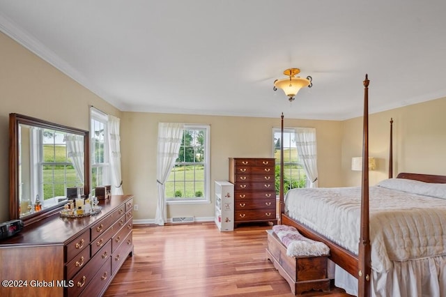 bedroom with light wood-type flooring and crown molding