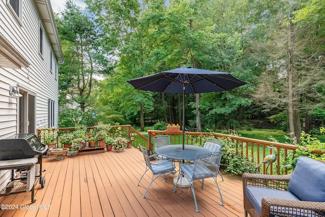 wooden terrace featuring outdoor dining area and grilling area