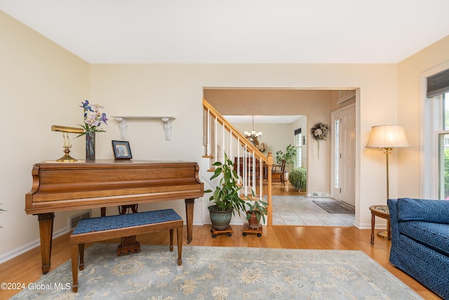entrance foyer featuring stairs, baseboards, a notable chandelier, and wood finished floors
