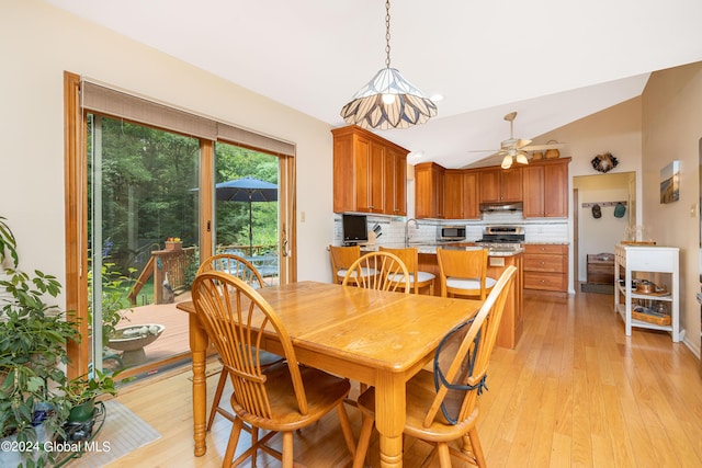 dining room featuring ceiling fan, light wood-type flooring, and lofted ceiling
