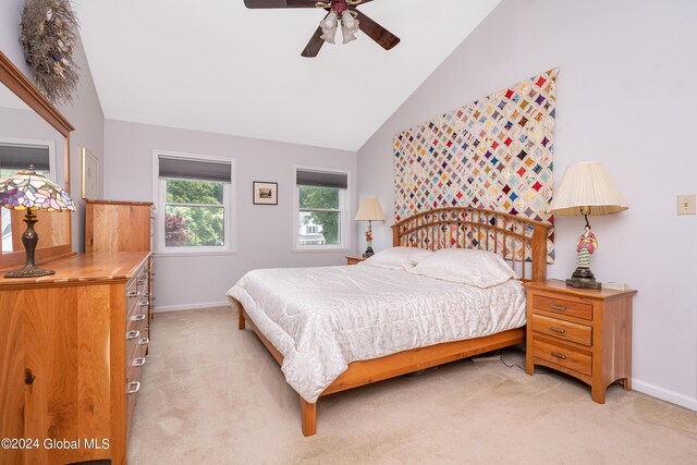 bedroom with a ceiling fan, baseboards, vaulted ceiling, and light carpet