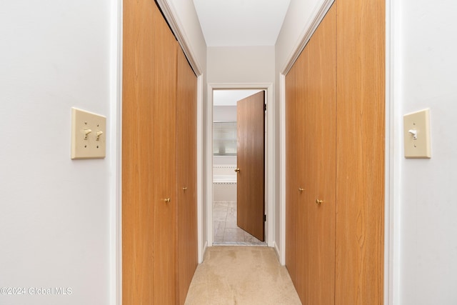 corridor with light tile patterned floors and light colored carpet