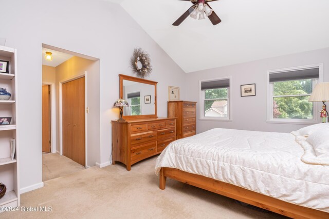 bedroom with ceiling fan, lofted ceiling, and light colored carpet