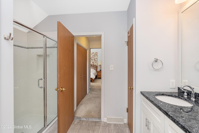 bathroom with vanity, ensuite bathroom, a stall shower, and vaulted ceiling