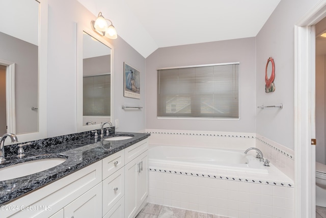 full bathroom with a sink, double vanity, toilet, and a bath