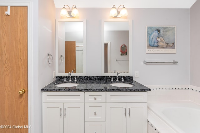 full bath featuring a sink, a bathtub, and double vanity