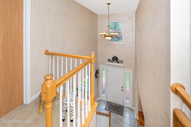 tiled foyer entrance with a notable chandelier