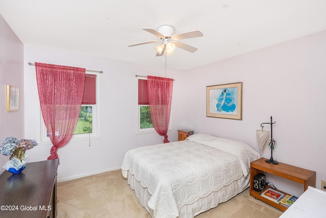 bedroom featuring baseboards, ceiling fan, and light carpet
