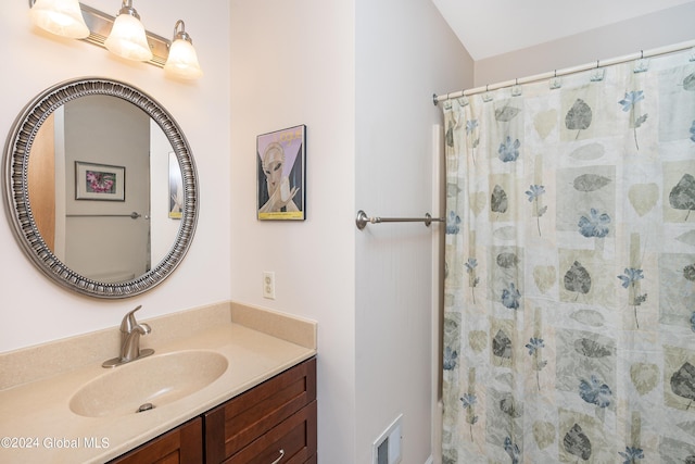 bathroom with vanity, curtained shower, and visible vents