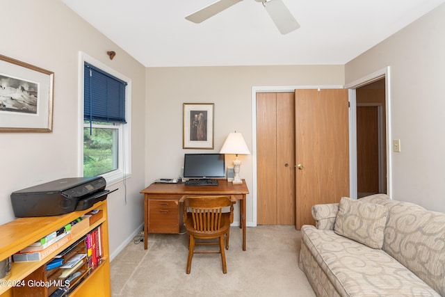 home office with light colored carpet, a ceiling fan, and baseboards