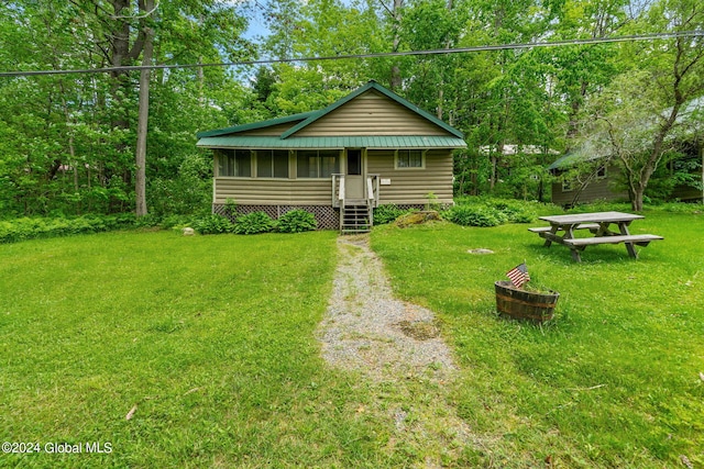 rear view of property featuring a sunroom and a lawn