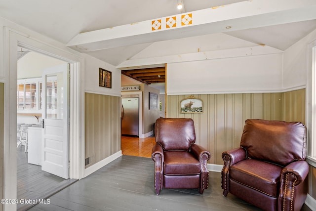 living area with vaulted ceiling with beams and hardwood / wood-style floors