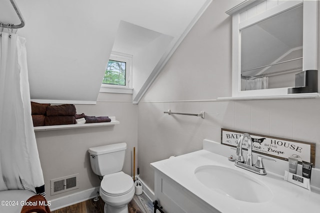 bathroom featuring hardwood / wood-style floors, vanity, toilet, and tile walls