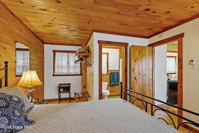 bedroom with wood ceiling, wood-type flooring, connected bathroom, and multiple windows