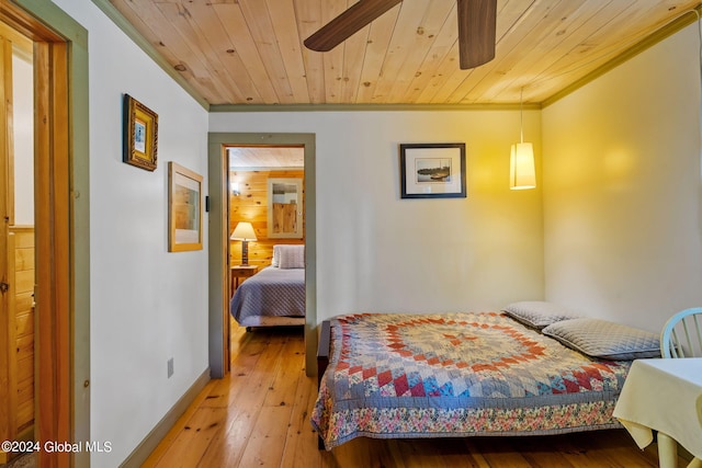 bedroom featuring ceiling fan, hardwood / wood-style flooring, wood ceiling, and crown molding