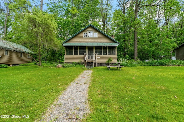 bungalow-style home with a front yard and a sunroom