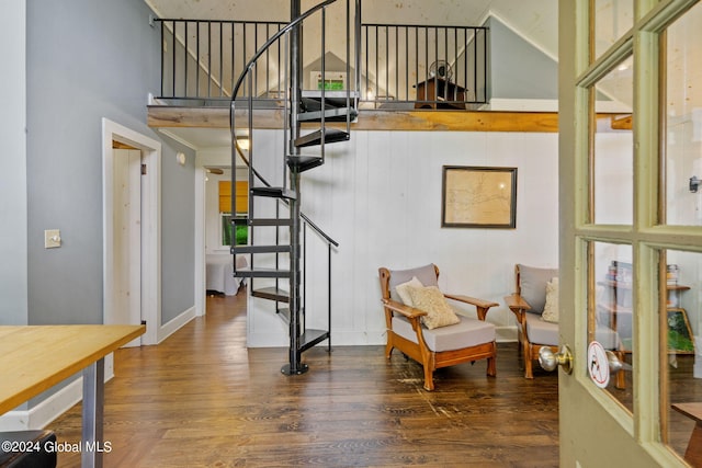 interior space with a towering ceiling and hardwood / wood-style flooring