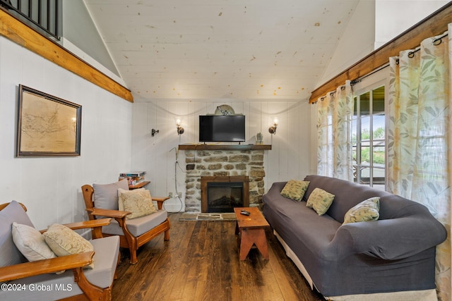 living room featuring a stone fireplace, hardwood / wood-style flooring, and vaulted ceiling