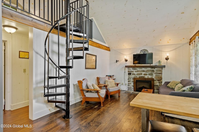 living room featuring wood-type flooring, a fireplace, and vaulted ceiling