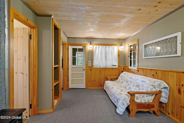 living area featuring dark colored carpet and wood ceiling