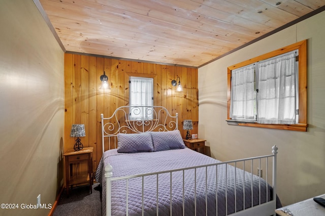 bedroom with wooden ceiling, carpet, and multiple windows