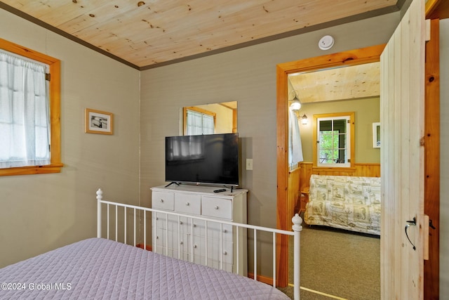 bedroom featuring wood ceiling and carpet