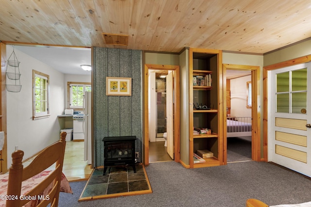 living room featuring wooden ceiling, hardwood / wood-style flooring, and a wood stove