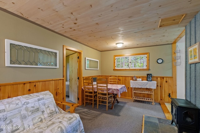 bedroom featuring wood ceiling, carpet floors, and a wood stove