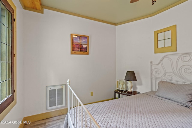 bedroom with ornamental molding and wood-type flooring