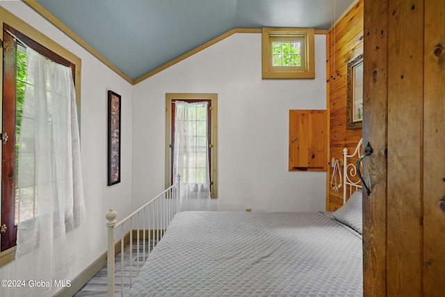 hallway with carpet flooring, wooden walls, and lofted ceiling