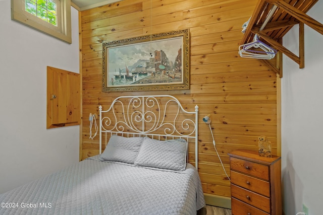 bedroom featuring wood walls