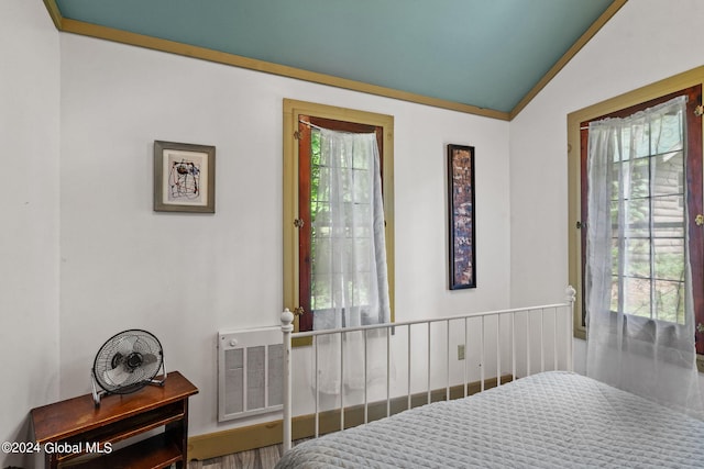 bedroom with lofted ceiling and multiple windows