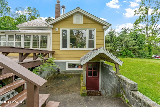 rear view of property featuring a lawn