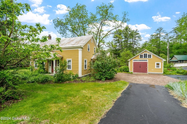 view of front of home with a front lawn and a shed