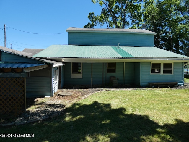 back of house featuring a lawn