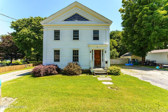 neoclassical home with a front lawn