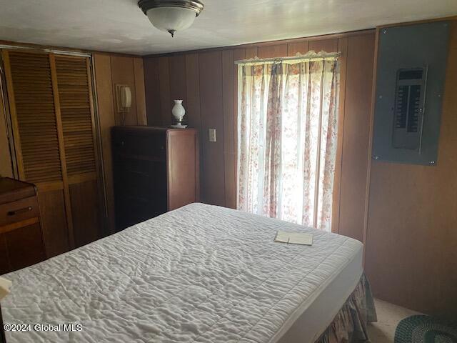 302 Edwards Hill Rd, Johnsburg, NY 12811 - bedroom with wooden walls, electric panel, and a closet