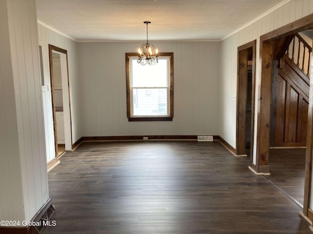 unfurnished room featuring ornamental molding, a notable chandelier, wood walls, and dark hardwood / wood-style flooring