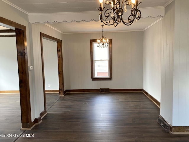 empty room featuring ornamental molding, wooden walls, dark wood-type flooring, and a chandelier