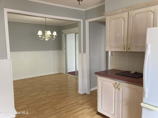 kitchen with pendant lighting, ornamental molding, light hardwood / wood-style flooring, backsplash, and white fridge