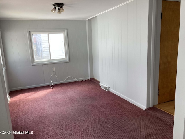 carpeted spare room featuring ornamental molding