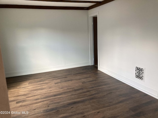 empty room with beam ceiling and dark wood-type flooring