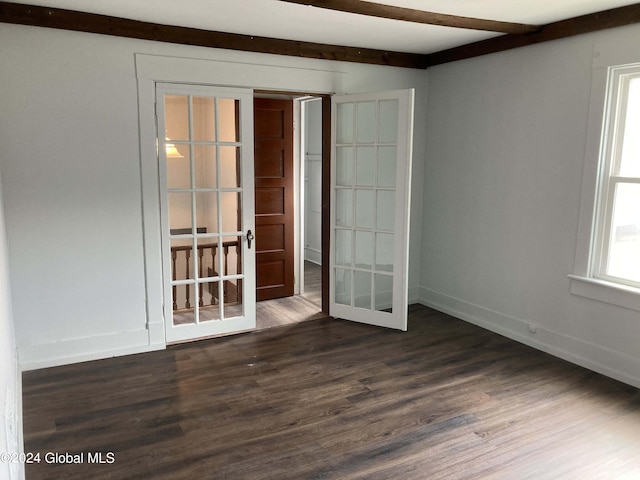 spare room with french doors, dark hardwood / wood-style floors, and beam ceiling